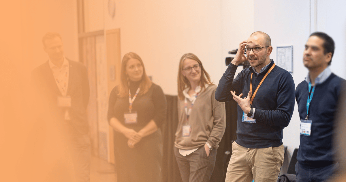 Diverse team of professionals collaborating and building on each other's ideas during an interactive improv-based innovation workshop.